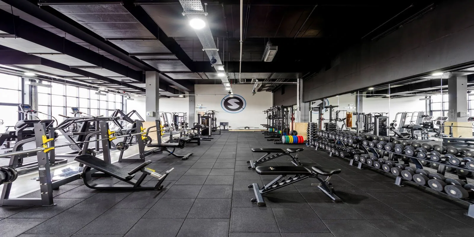 Representative hotel space: A gym with rows of exercise machines and free weights.