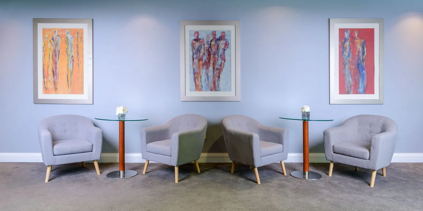 Representative hotel space: A lounge seating area features four upholstered chairs and colorful framed artwork.