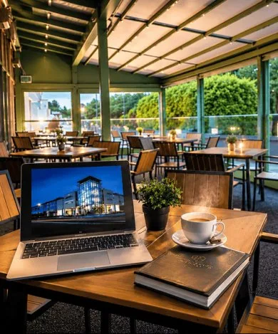 Representative hotel space: A covered dining area with tables and a laptop in the foreground.