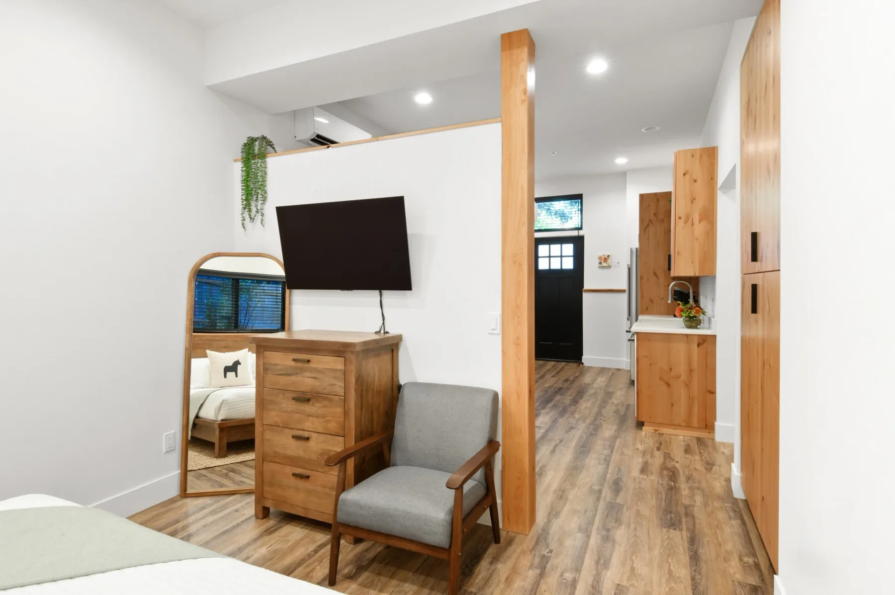 Representative hotel space: A bedroom seating area with a television beside an open kitchenette.