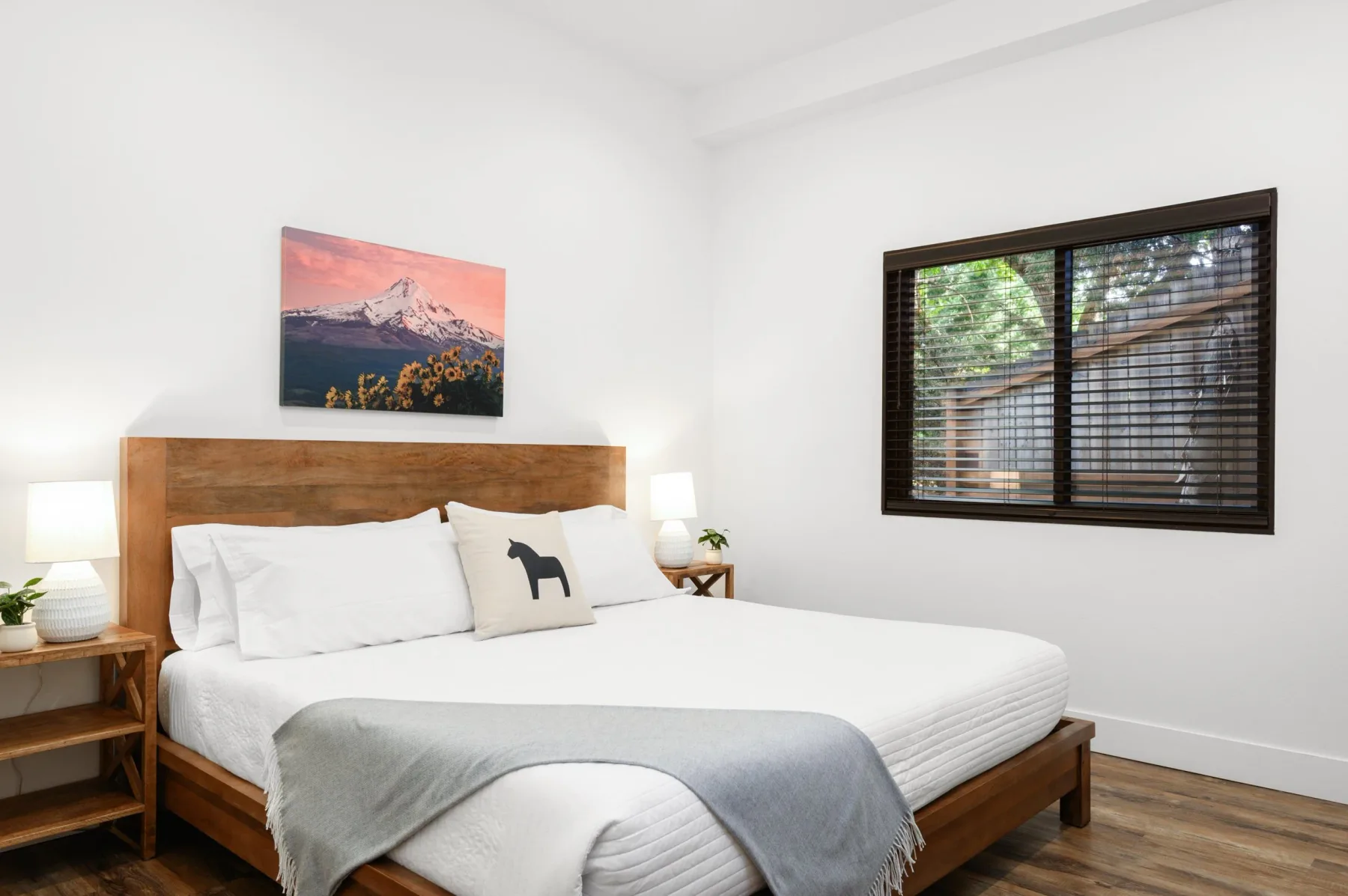 Representative hotel space: A bedroom with a neatly made bed and a window with dark blinds.