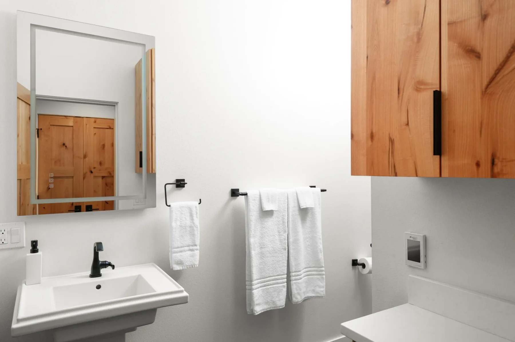 Representative hotel space: A bathroom vanity with a mirror and towels hanging on the wall.