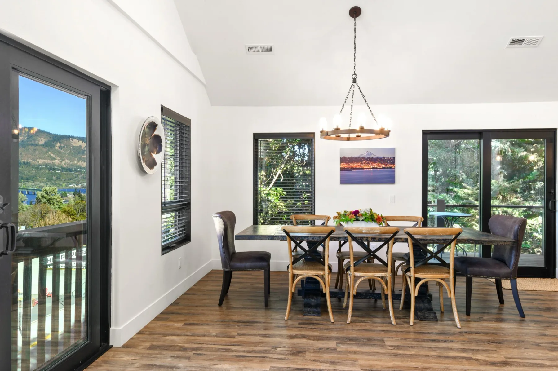 Representative hotel space: A bright dining area with a wooden table and chairs beside large windows.