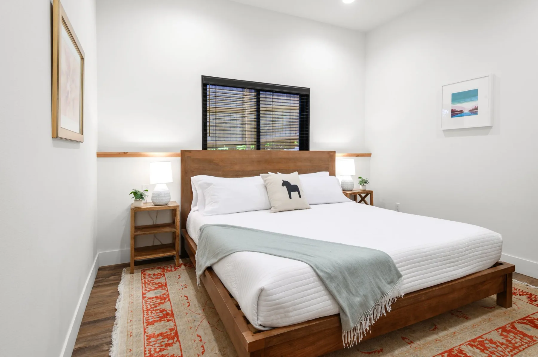 Representative hotel space: A bedroom with a wooden bed, white bedding, and a rug.