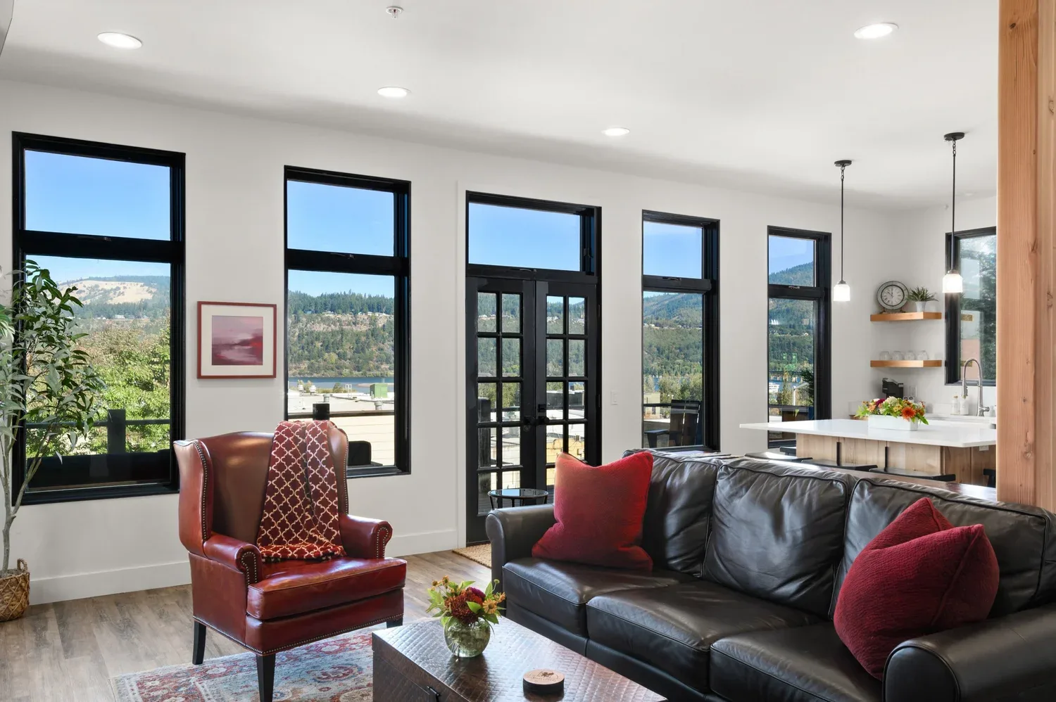 Representative hotel space: A living room with leather seating and large windows overlooking a green landscape.