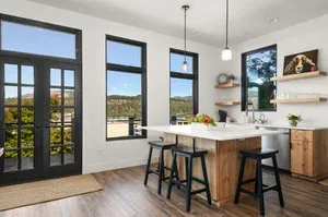Representative hotel space: A bright kitchen and dining area with a central island and tall windows.