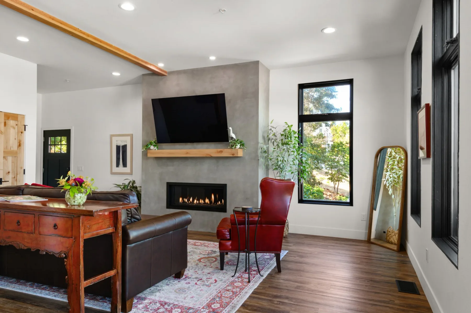Representative hotel space: A living room with a television above a fireplace and seating.