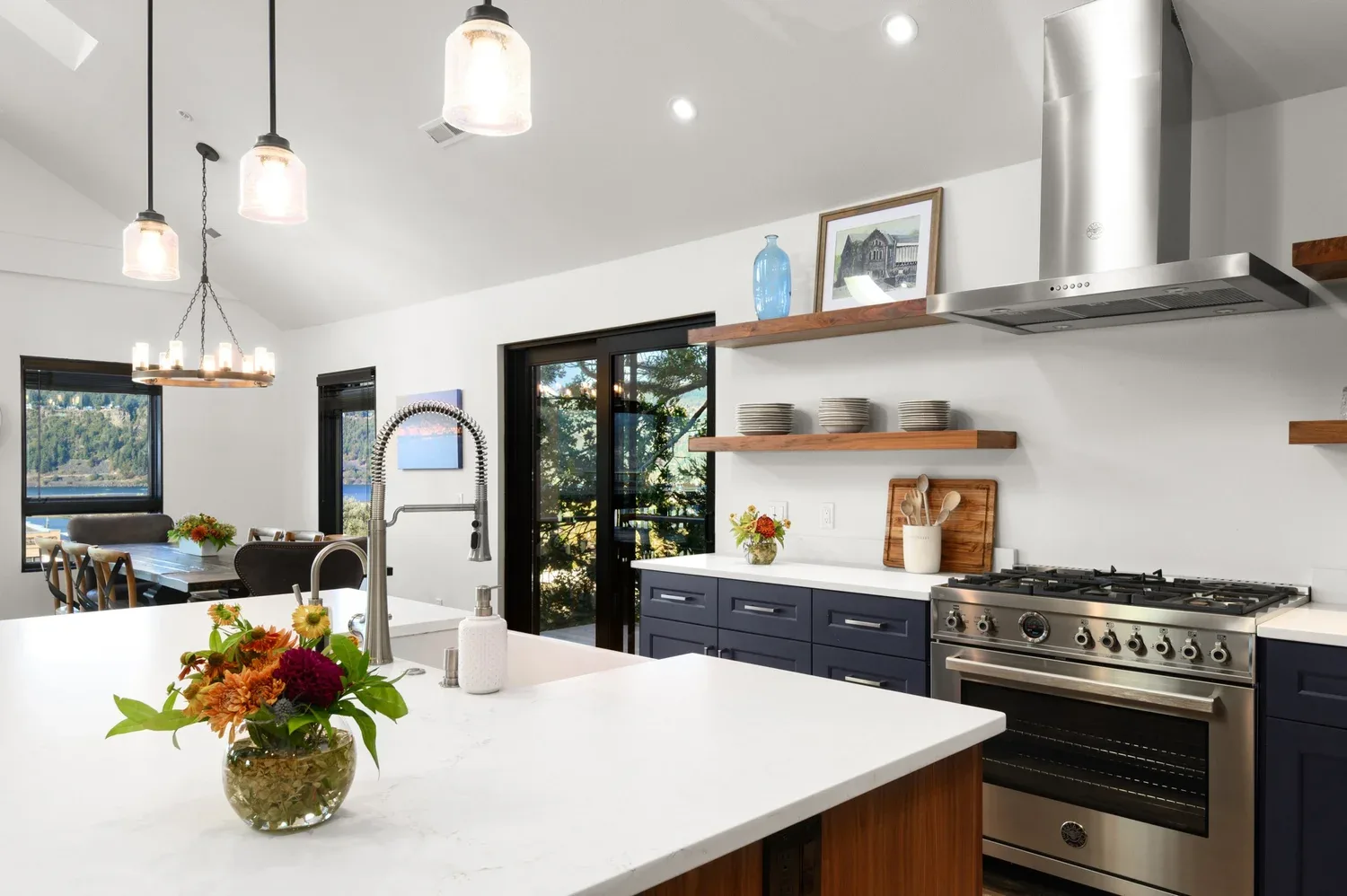 Representative hotel space: A bright kitchen with a large island, open shelves, and a stainless-steel range.