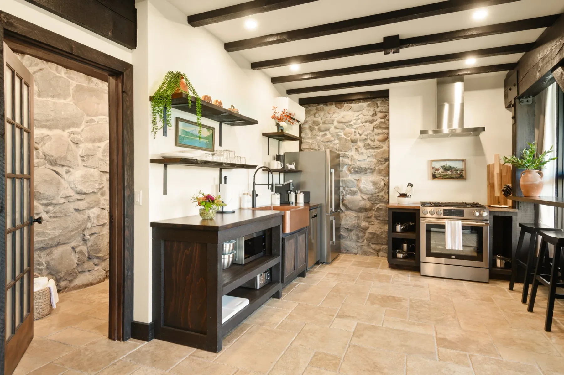 Representative hotel space: A rustic kitchen with a central island, appliances, and dark ceiling beams.