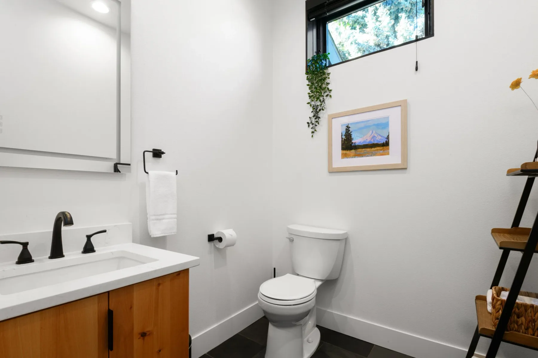 Representative hotel space: A bright bathroom with a sink, toilet, and framed artwork.