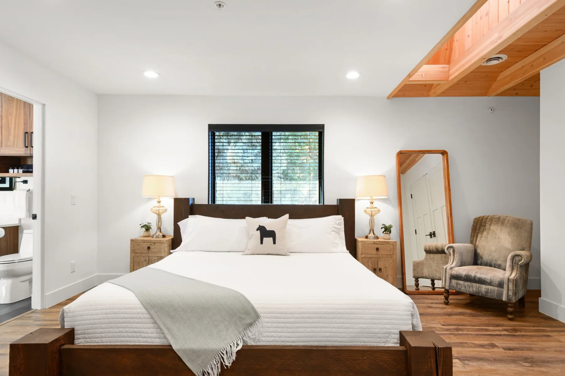 Representative hotel space: A bedroom with a bed beneath a window and matching bedside lamps.