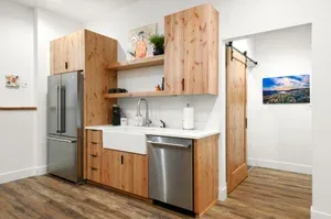 Representative hotel space: A compact kitchen with wood cabinets, stainless steel appliances, and a countertop.