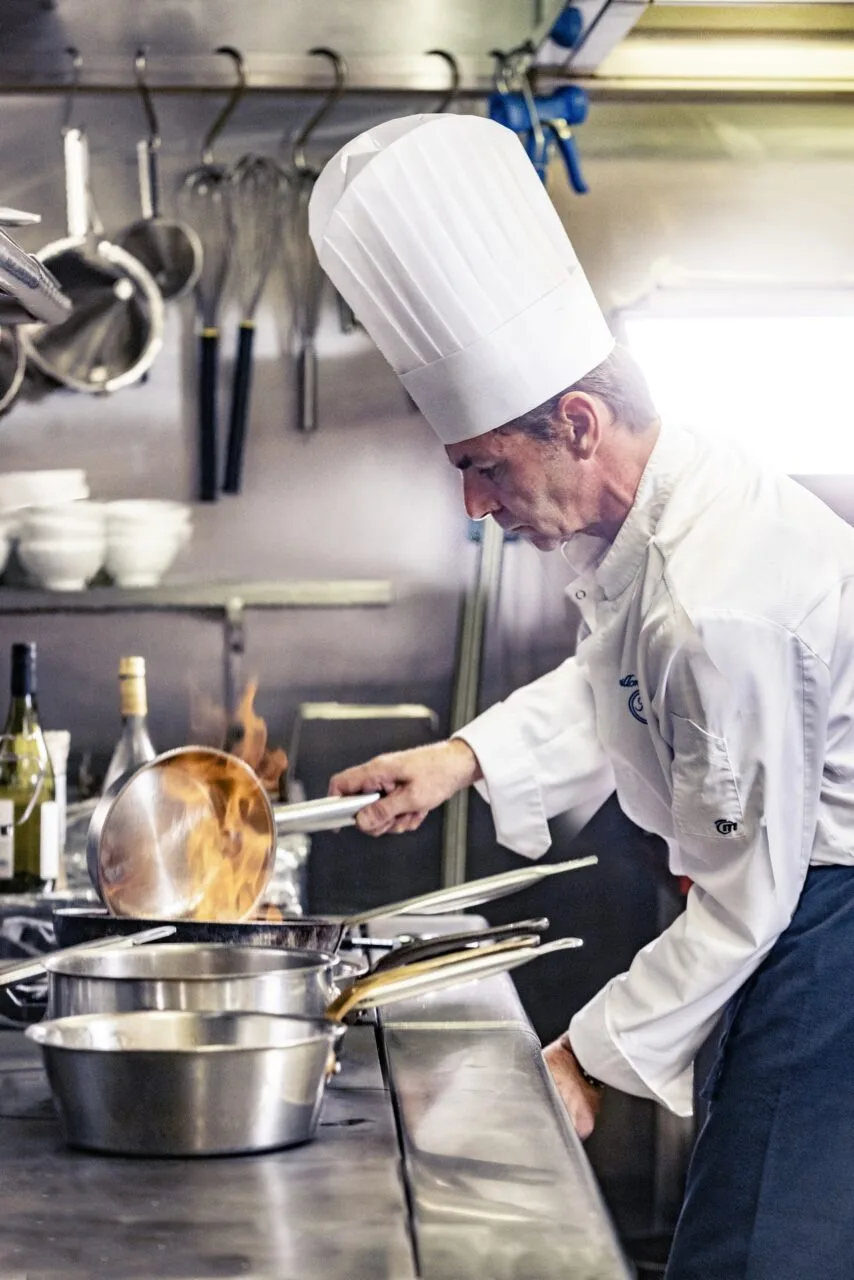 Espacio representativo del hotel: Un chef trabaja en una estufa en una cocina comercial.