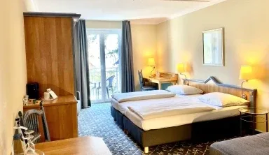 Representative hotel space: A hotel bedroom with two beds, bedside lamps, and a wardrobe.