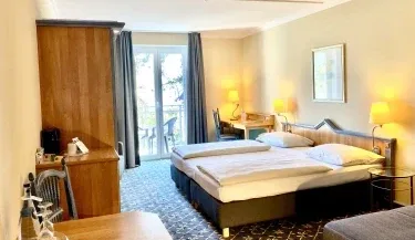 Representative hotel space: A hotel bedroom with a large bed, a window, and bedside lamps.
