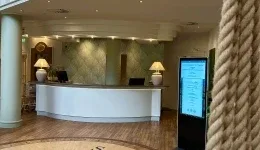 Representative hotel space: A hotel reception desk stands beneath warm lighting.