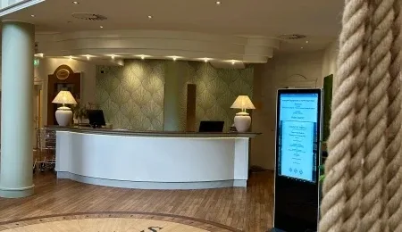 Representative hotel space: A hotel reception desk with lamps and a digital information display.