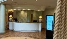 Representative hotel space: A hotel reception desk stands beneath recessed ceiling lights.