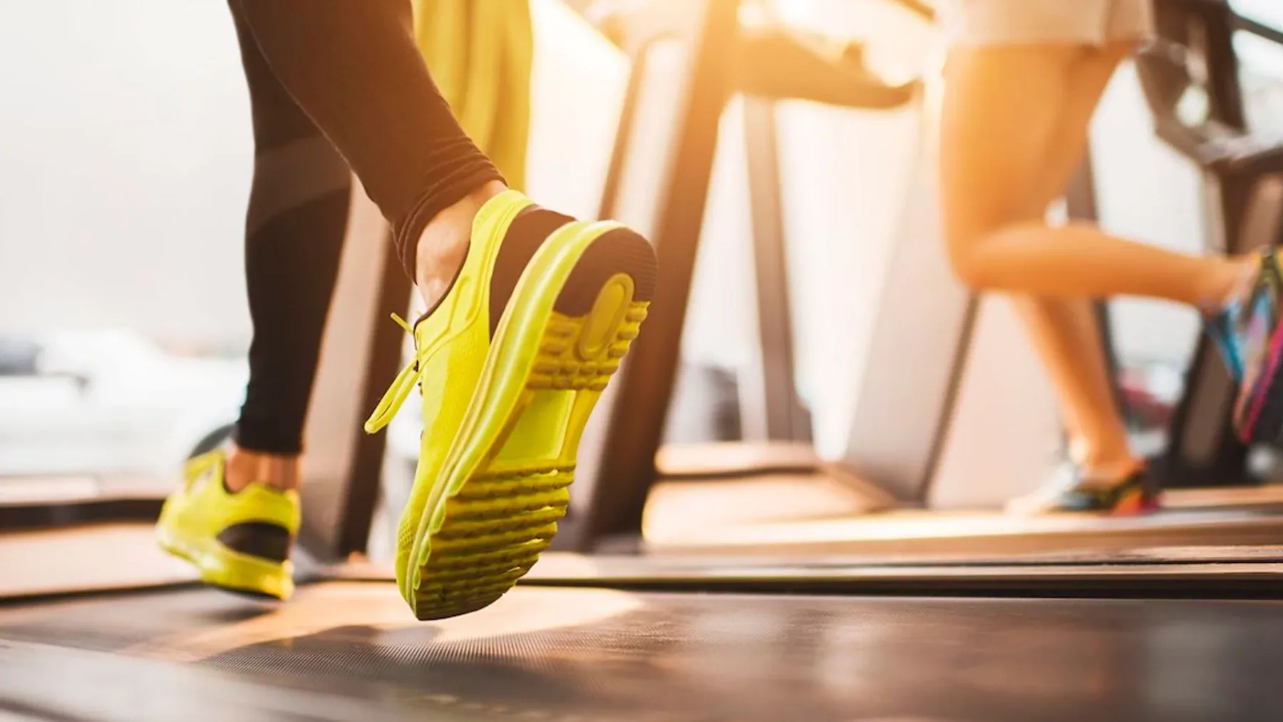 Representative hotel space: A person runs on a treadmill wearing bright yellow shoes.