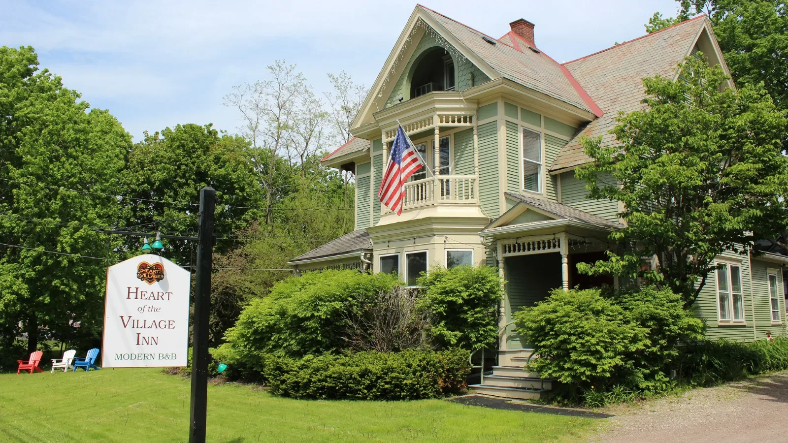 Representative hotel space: A large green house with balconies stands beside a landscaped lawn.