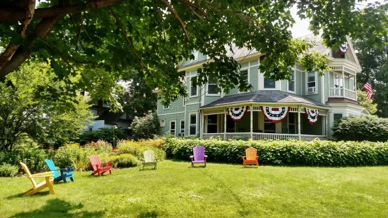 Representative hotel space: A large green house overlooks a lawn with colorful outdoor seating.