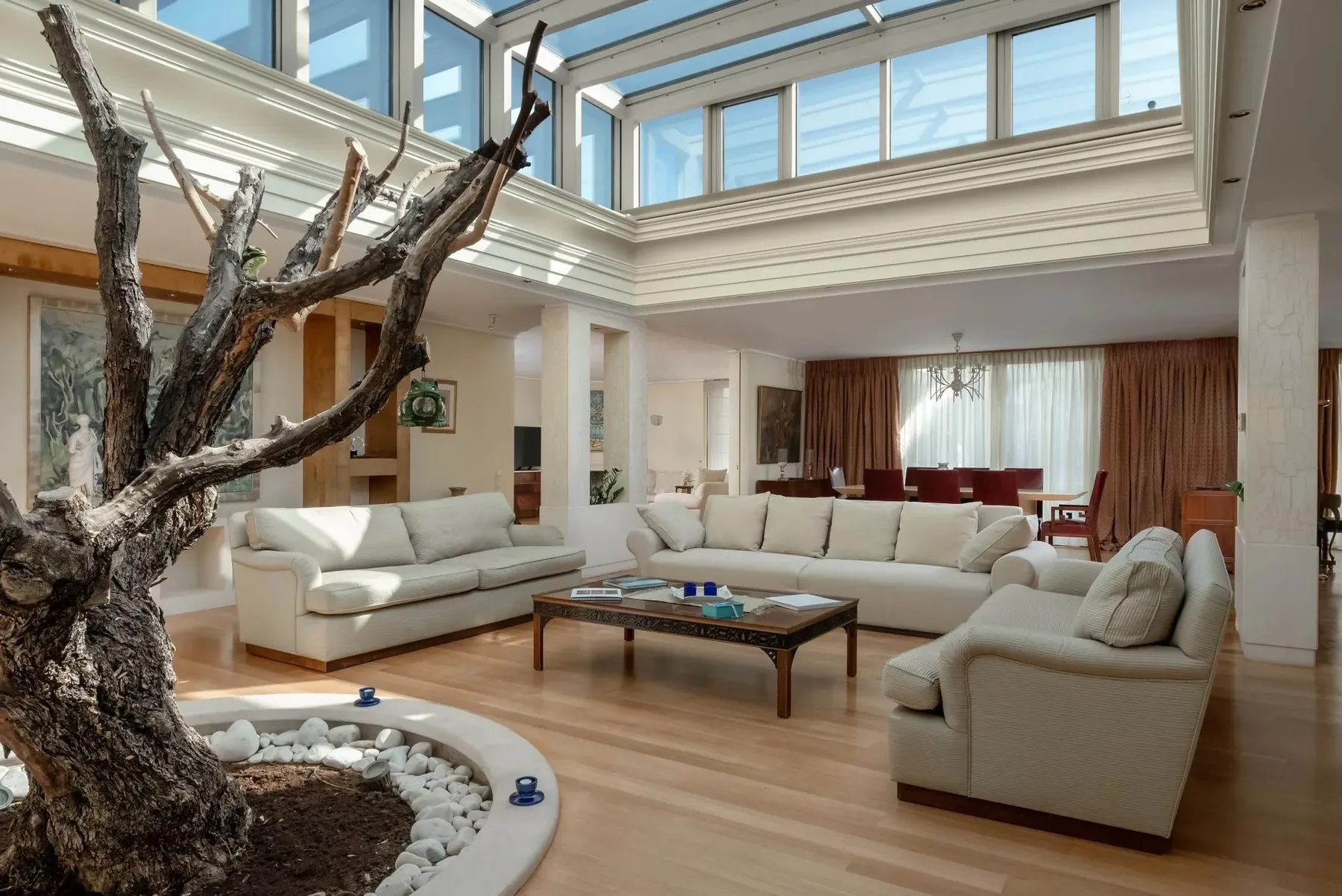 A bright living room with cream seating arranged around a coffee table.