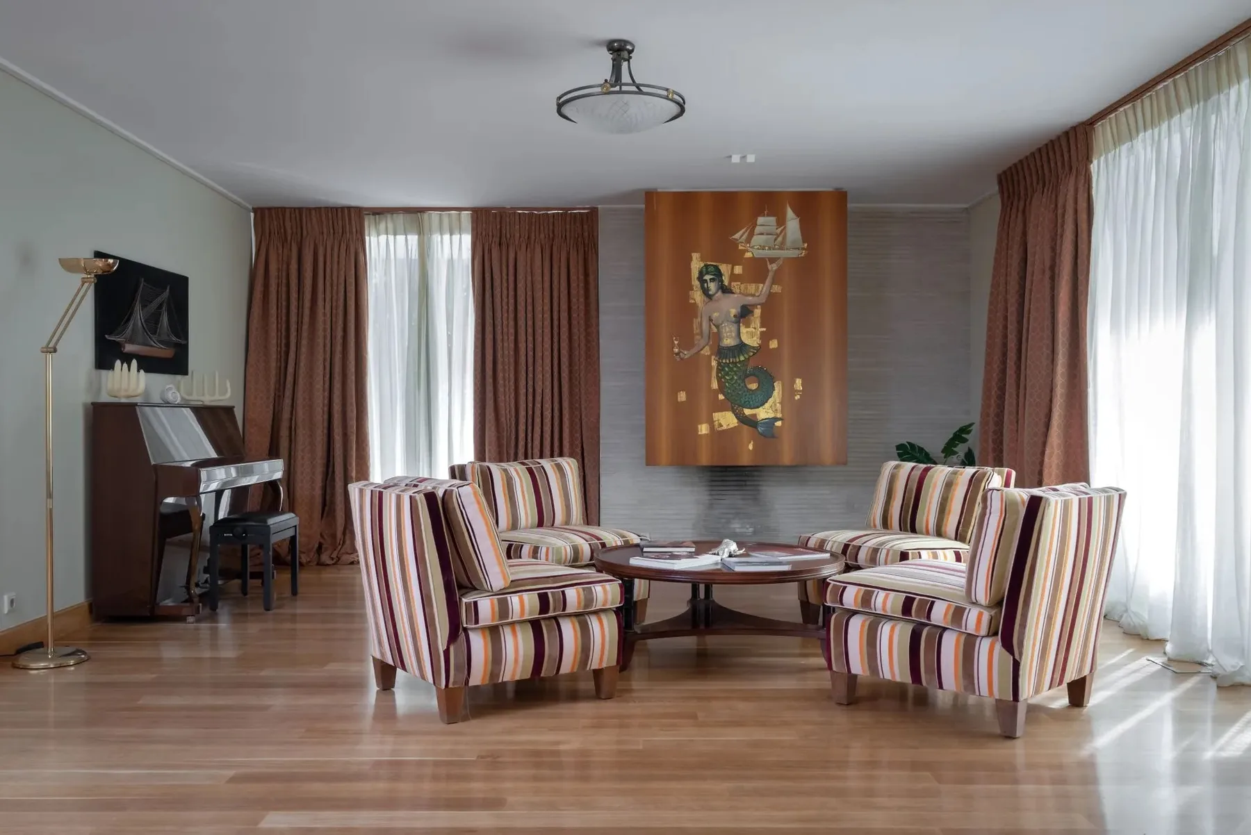 A sitting room with striped seating arranged around a low table.