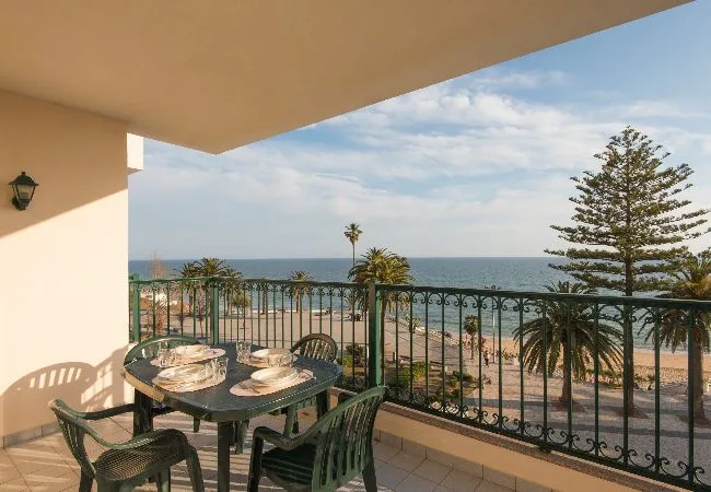 Una zona de comedor en el balcón da a la playa y al mar.