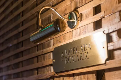 Espacio representativo del hotel: Una lámpara de pared ilumina una placa en una pared de madera.