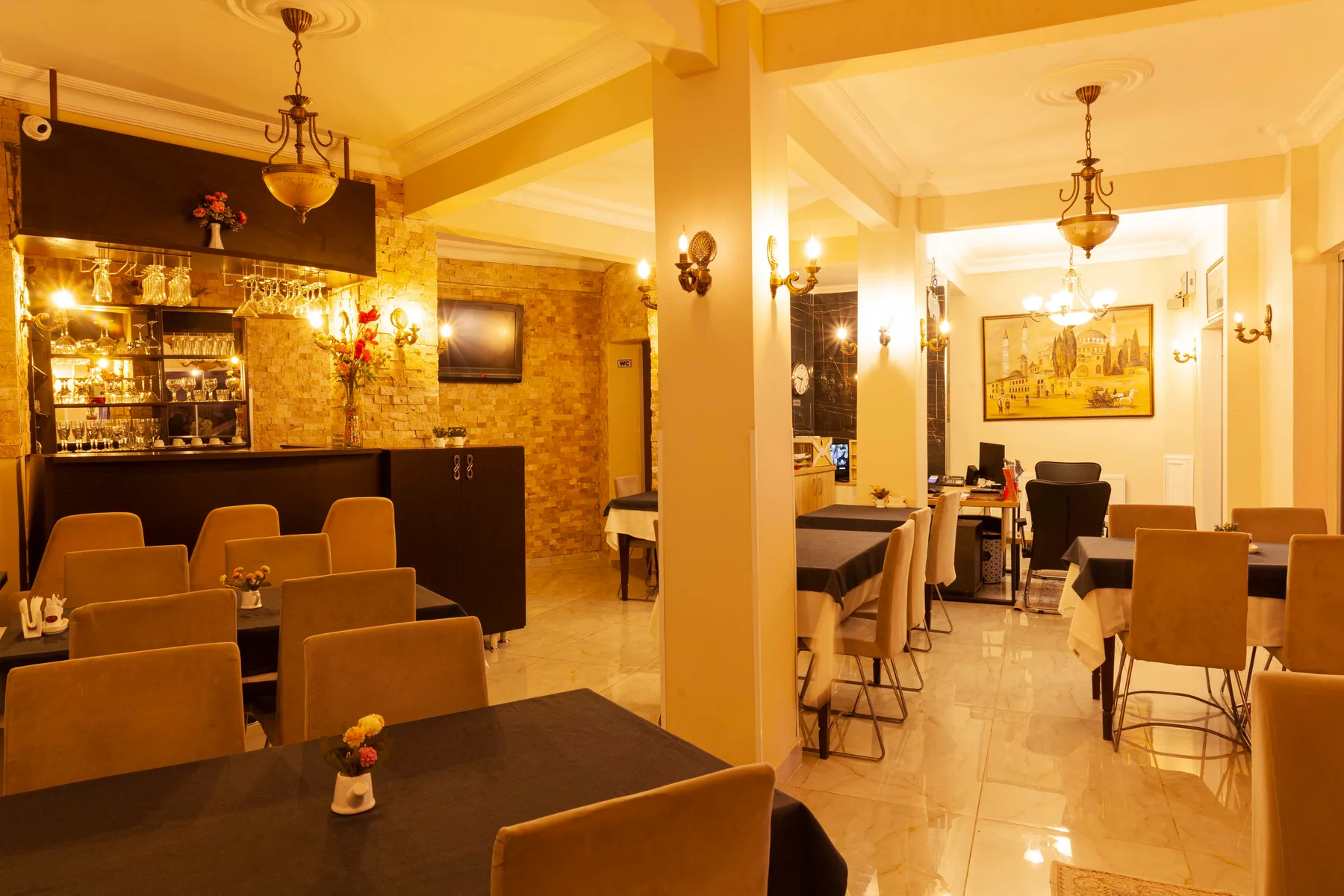 Espacio representativo del hotel: Comedor cálidamente iluminado con mesas, asientos y una barra.