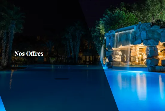 Espacio representativo del hotel: Una piscina al aire libre brilla en azul junto a un muro iluminado por la noche.
