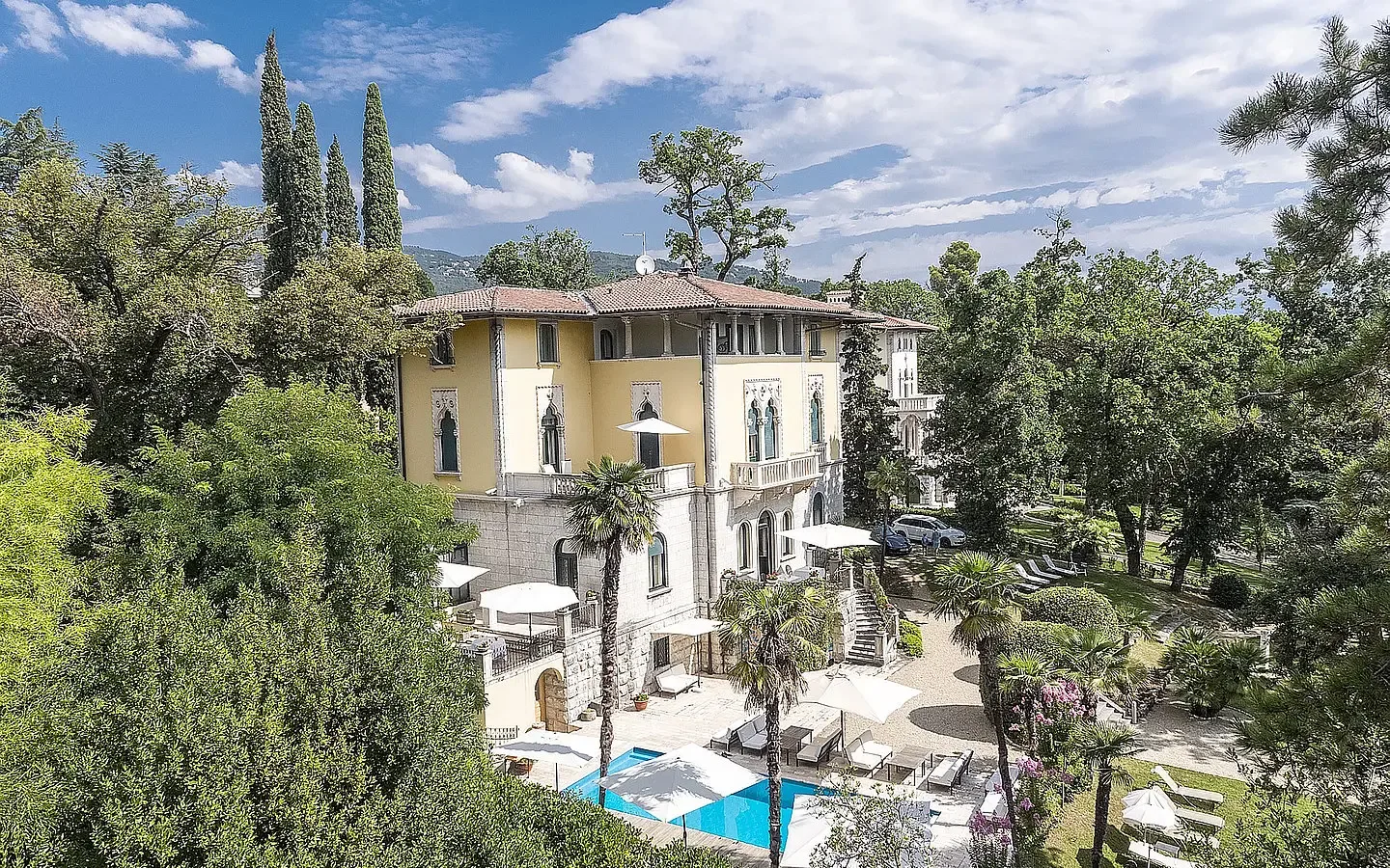 Representative hotel space: A hotel building and outdoor pool sit among leafy gardens.