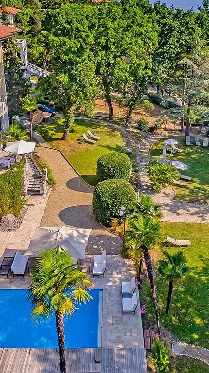 Representative hotel space: A landscaped garden surrounds a swimming pool and winding paths.