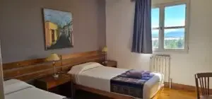 Representative hotel space: A bedroom with two beds and a window overlooking the water.