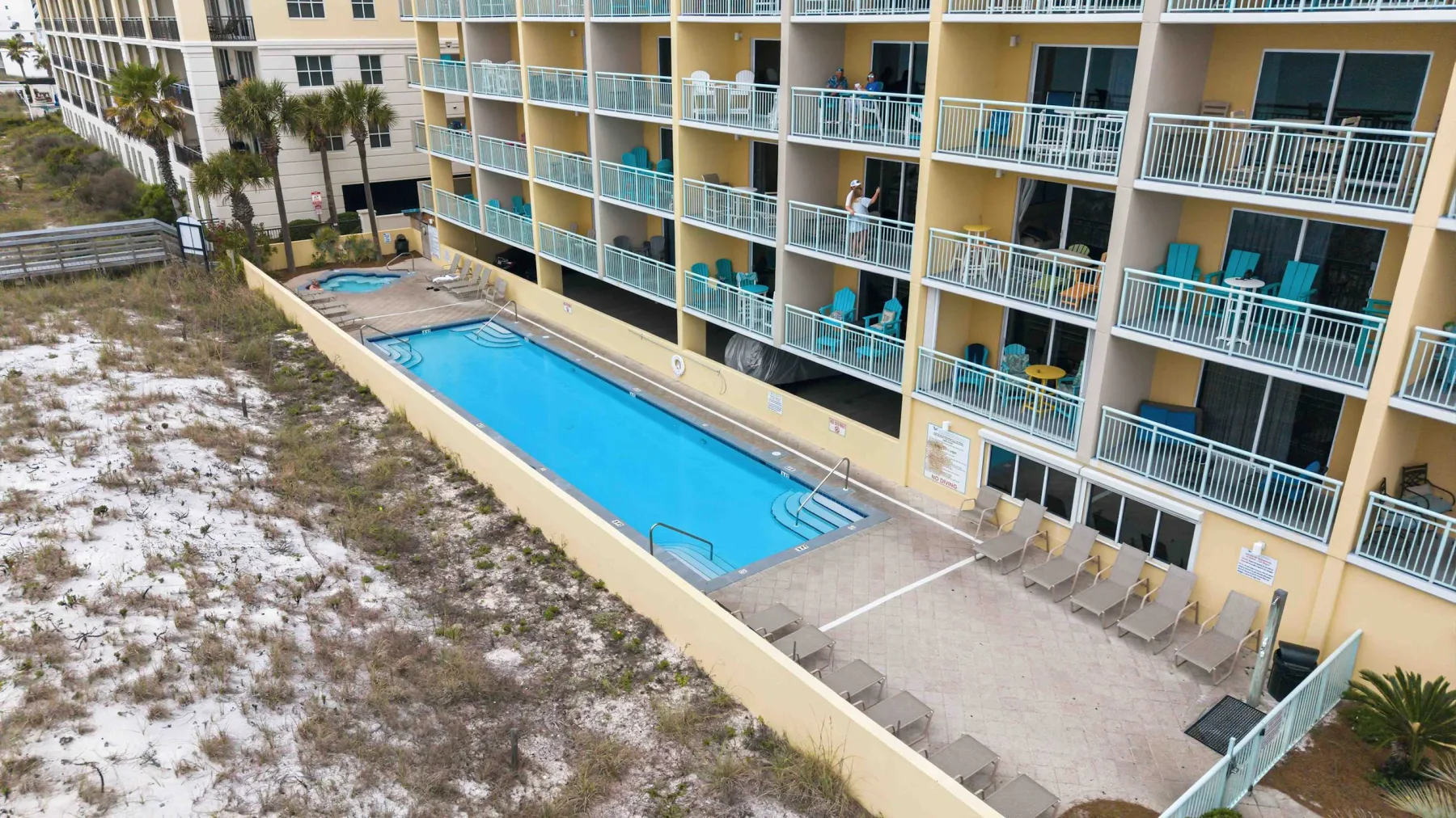 Zona común: Una piscina al aire libre junto a un edificio de apartamentos con balcones.