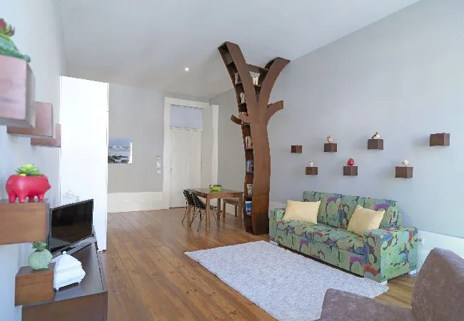 A living room with a patterned sofa and a wooden dining table.