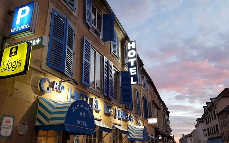 Representative hotel space: A hotel exterior with illuminated signs and blue window shutters.