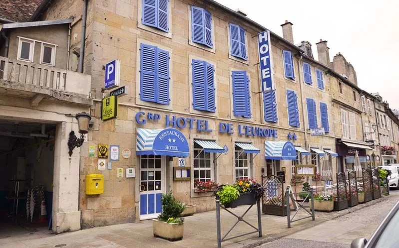 Representative hotel space: A hotel façade with blue shutters, awnings, and flower planters along the street.