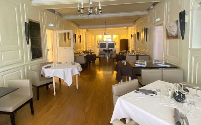 Representative hotel space: A formal dining room with tables set with white tablecloths.