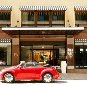 Representative hotel space: A hotel entrance with a red car parked in front.