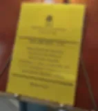 Espacio representativo del hotel: Un aviso impreso amarillo aparece sobre un fondo rojizo.