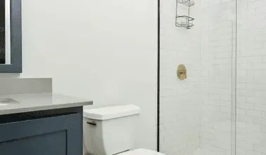 Un baño con lavabo, inodoro y zona de ducha con azulejos.