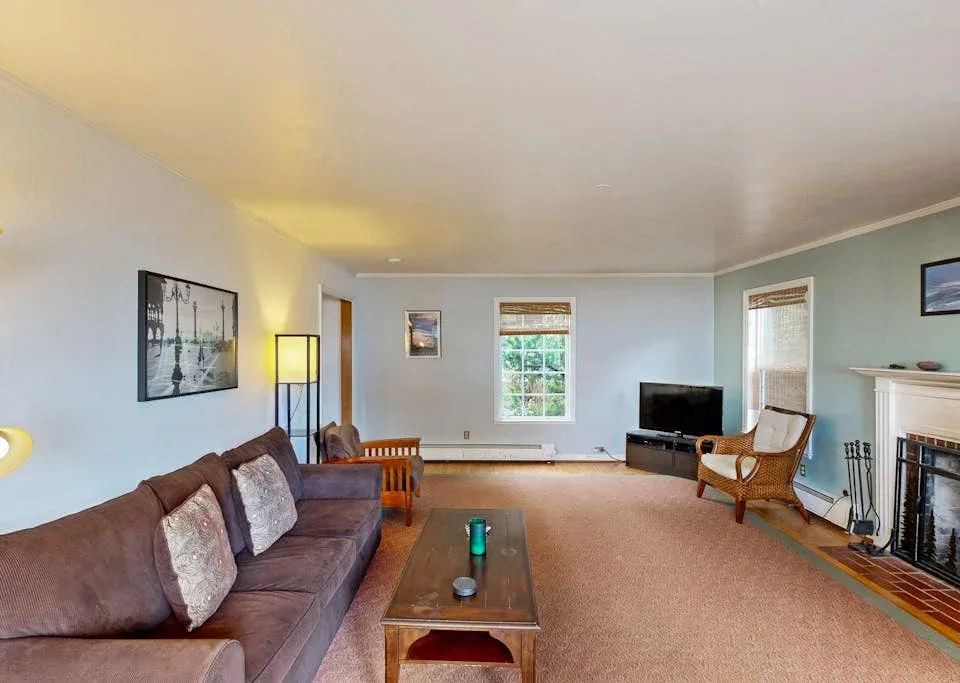 A living room with seating, a coffee table, and a television.