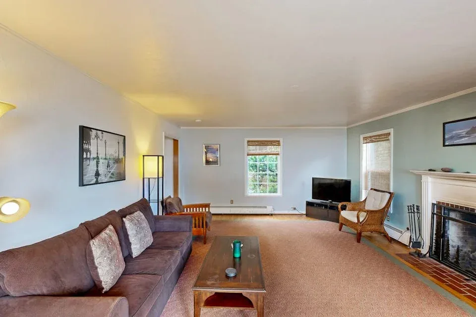 A living room with seating, a coffee table, and a fireplace.