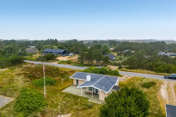 Vista aérea de una casa independiente junto a una carretera, rodeada de vegetación.