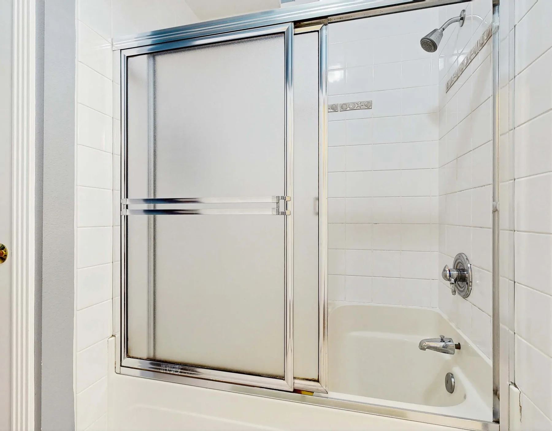 Baño con azulejos, bañera y ducha.