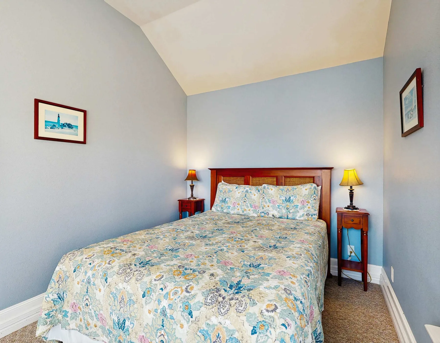 Un dormitorio con una cama cubierta con una colcha de estampado floral y almohadas a juego.