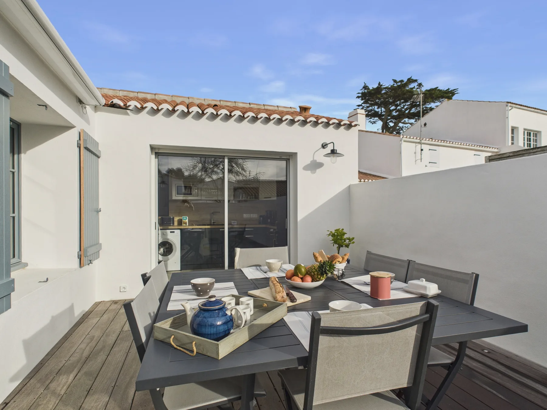 Outdoor dining area with a table set with dishes and food.