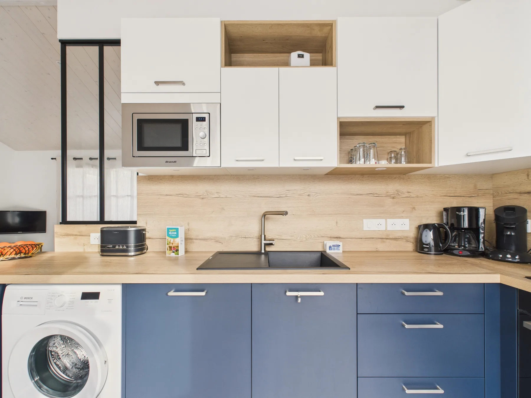 A modern kitchen with blue lower cabinets, a countertop, and a sink.