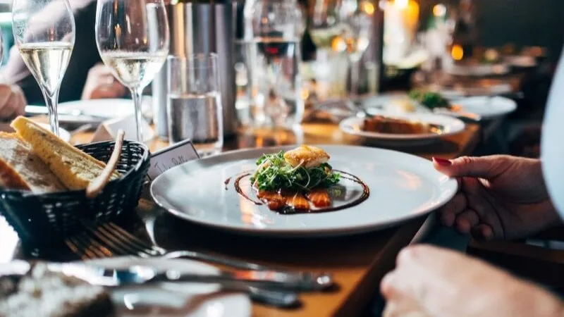 Espacio representativo del hotel: Se sirve un plato en una mesa de restaurante con copas de vino.